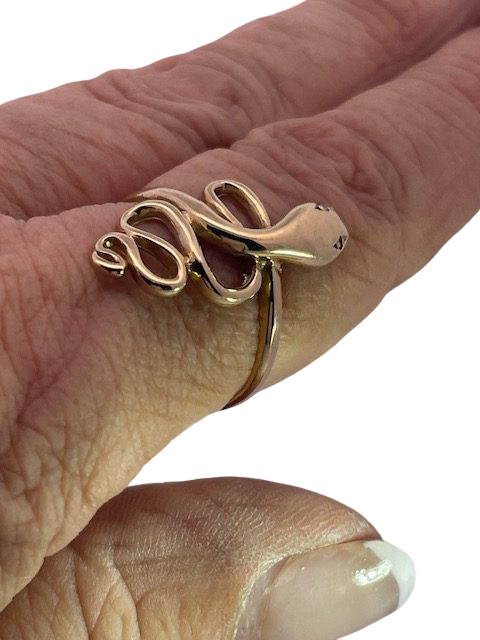 Gold snake-shaped ring on a finger